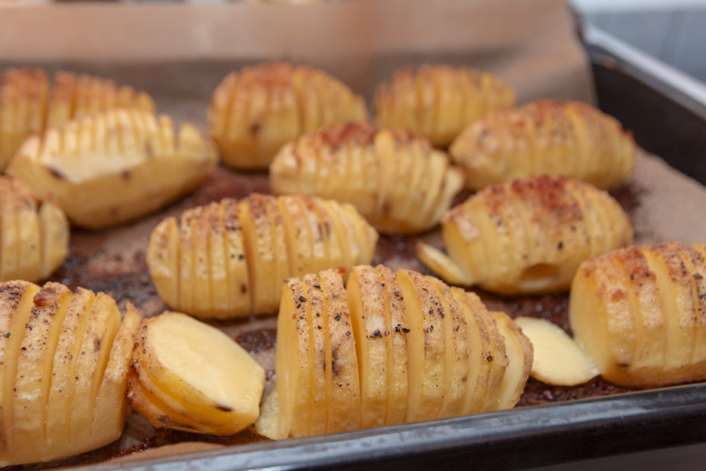 Hasselback potatoes in a frying pan.