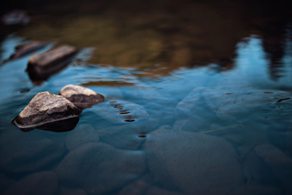 Rocks in stream with smooth flowing water