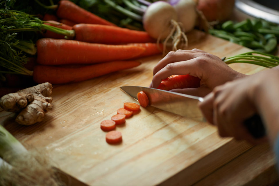 Shot of a woman cutting vegetables on a cutting board