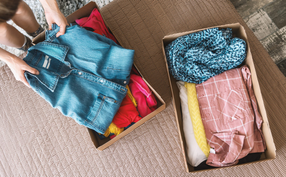 Woman preparing used clothes for clothing swap.