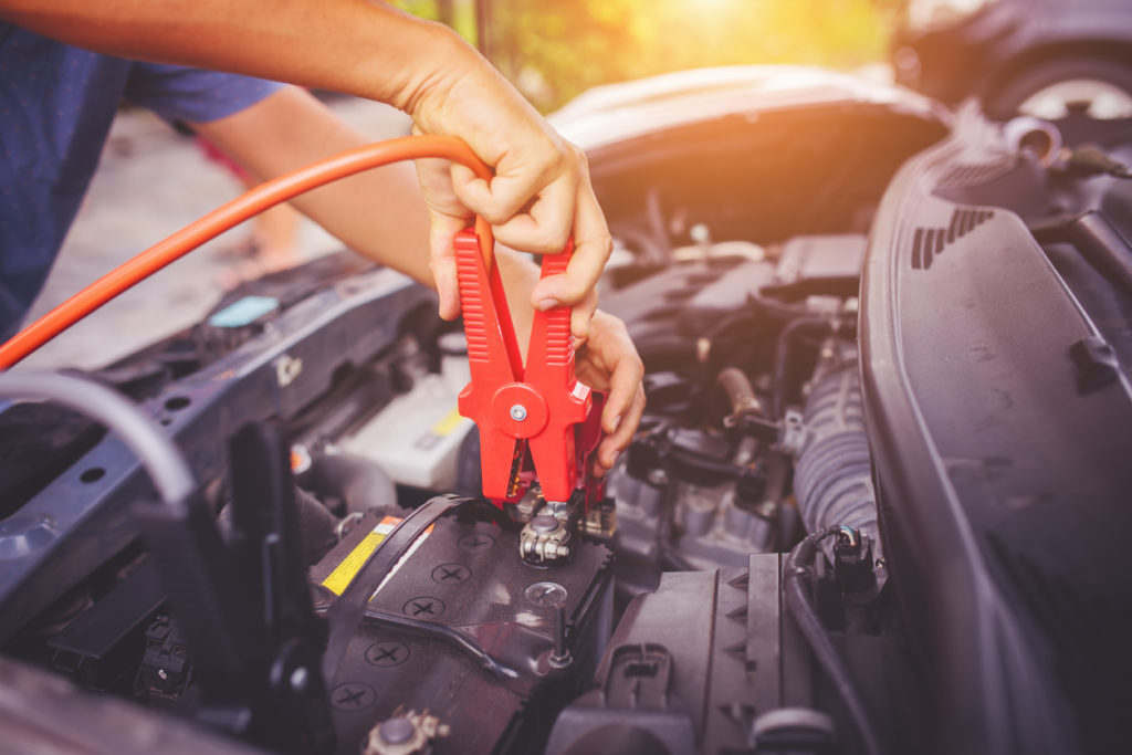 Close up of auto mechanic jumping battery