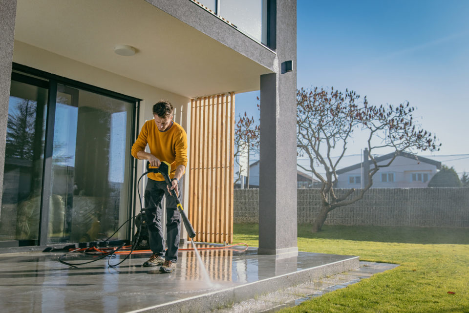 Man cleaning the terrace tiles of the apartment