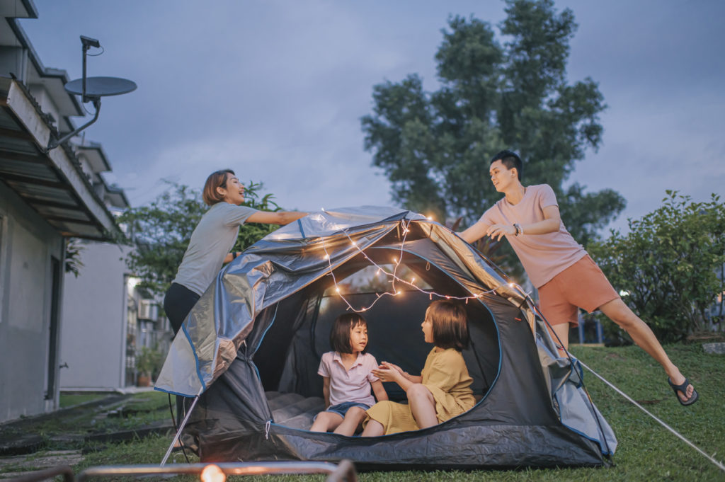 family using string lights while camping