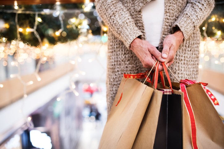  woman with paper bags doing Christmas shopping. Shopping center at Christmas time.